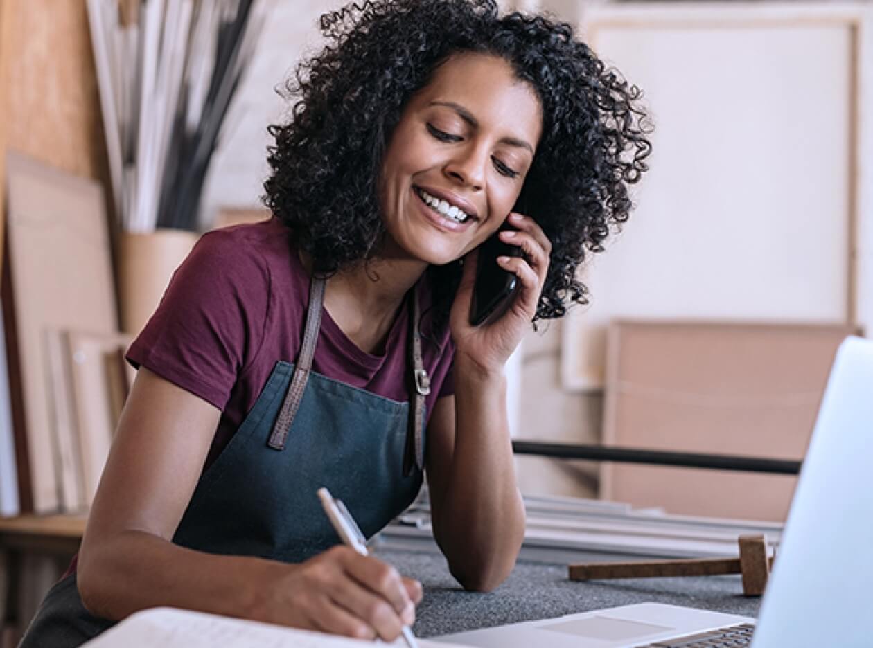 masked young male seated at bar on the phone